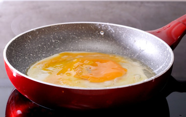 preparing scrambled eggs in a frying pan at home