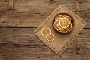 Fototapeta na wymiar Dried slices of lemon in bowl. Fruit snack, healthy eating concept