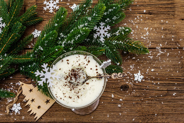 Traditional prune dessert with nuts and whipped sour cream with sugar. New Year's sweet treat concept. Wooden boards background