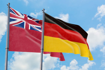 Germany and Bermuda flags waving in the wind against white cloudy blue sky together. Diplomacy concept, international relations.