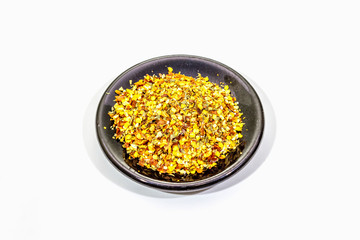 Hot seasoning in plate isolated on white background. Mix of different spices and sea salt. Traditional ingredient for cooking Italian food