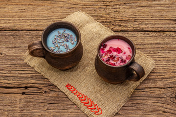 Moon Milk for a better sleep. Rose petals and lavender, felt heart. Valentines Day, romantic concept. Trendy relaxing bedtime drink. Old wooden background