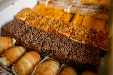 Shallow depth of field (selective focus) image with details of various types of sweet cakes.