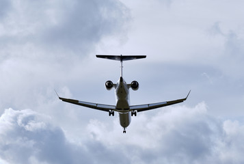 Aeroplane seen from below against a cloudy sky while landing in Germany