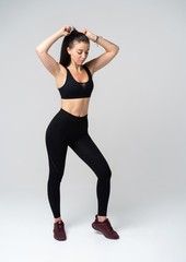 Fototapeta na wymiar Young fit woman in sports outfit, studio photo.