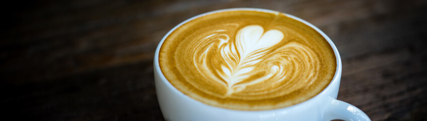 Closeup food and drink of hot coffee latte on dark wooden table with copy space using as background food cover page, coffee day concept.  