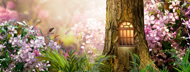 Enchanted fairy tale forest with magical shining window in hollow of fantasy pine tree elf house,...