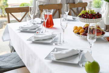 Terrace illuminated by light, a bowl of fruit. Well served table.