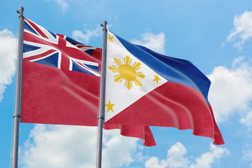 Philippines and Bermuda flags waving in the wind against white cloudy blue sky together. Diplomacy concept, international relations.