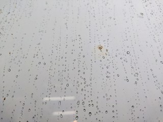 Water drops on glass, rain on a window background. drops of water-repellent surface in black &...