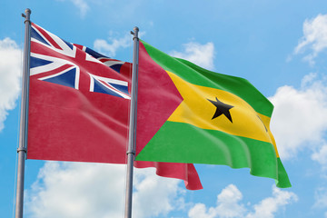 Sao Tome And Principe and Bermuda flags waving in the wind against white cloudy blue sky together....