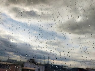 Water drops on glass, rain on a window background. drops of water-repellent surface in black &...