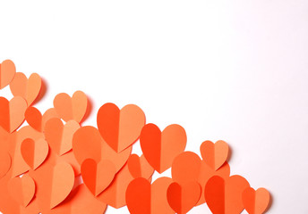 Orange paper hearts cutouts on white background with free space for your text