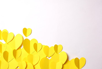 Yellow paper hearts cutouts on white background with empty space for custom text