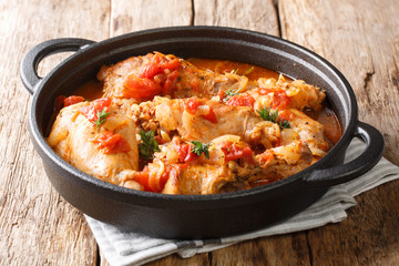 Tasty spicy rabbit stew in tomato sauce with white wine and herbs close-up in a pan. horizontal