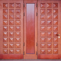 Massive doors made of dark red wood. Retro mahogany door