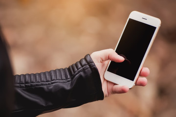 Smartphone with screen in woman hands. Girl using mobile phone outdoor.