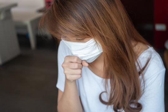 sick woman with face mask; concept of Wuhan virus, corona virus, H5N1, H1N1, bird flu, pig flu, avian influenza, swine influenza, pneumonia, lung inflammation, epidemic fever, flu viral infection