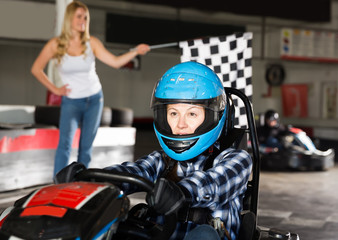 Nice female go-cart racer crossing finish line