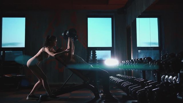 personal trainer with fitness woman exercising with dumbbells in gym
