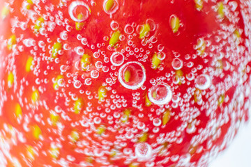 Ripe strawberries close-up in sparkling mineral water, macro photo. The concept of summer refreshing drinks, cocktails, organic healthy food.