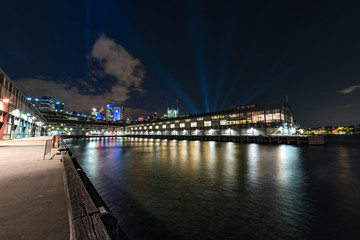 Fototapeta na wymiar Beautiful urban night scene with water and wharfs illuminated at night