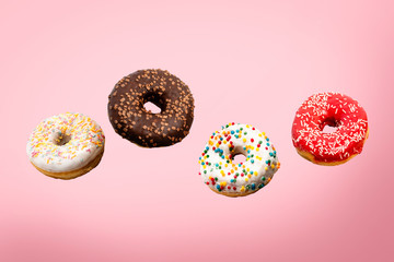 Donuts flying in the air on a pink background. Bakery, baking concept. Levitation. Banner