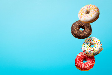 Donuts flying in the air on a blue background. Bakery, baking concept. Levitation