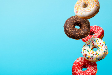 Donuts flying in the air on a blue background. Bakery, baking concept. Levitation