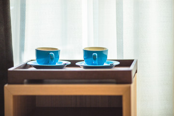 Blurred background view of a mug or coffee cup, a cup of water or a drink on the table, for customer service in a room or restaurant