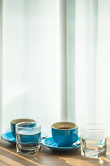 Blurred background view of a mug or coffee cup, a cup of water or a drink on the table, for customer service in a room or restaurant