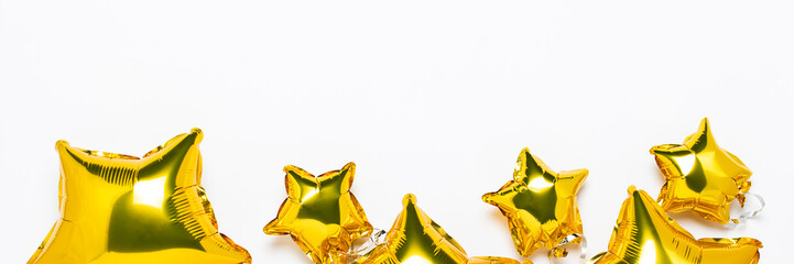 Air golden balloons star shape and candy on a white background. Concept for holiday, party, photo zone, decoration. Banner Flat lay, top view