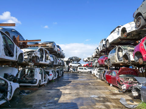 Large Salvage Car parts and Vehicles lot, with rows of stacked totalled Cars