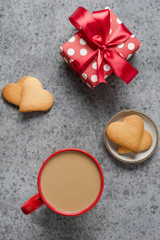 Obraz na płótnie Canvas Valentines day greeting card with heart cookies, gift, coffee cup on grey table. Vertical.
