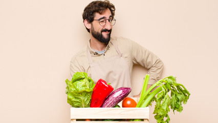 green grocery man looking happy and friendly, smiling and winking an eye at you with a positive...