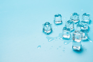 Ice cubes with water on a blue background. Ice concept for drinks. Banner. Flat lay, top view