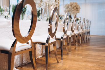 formal luxury elegant wedding decor restaurant tables served white tablecloth, plates, menus, glasses, tulips in vases, orchids, candles silver chairs, blue background