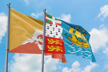 Saint Pierre And Miquelon and Bhutan flags waving in the wind against white cloudy blue sky together. Diplomacy concept, international relations.