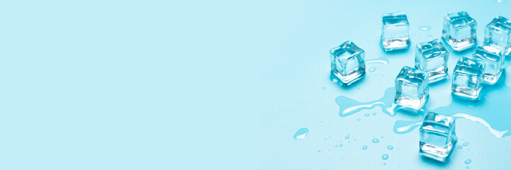 Ice cubes with water on a blue background. Ice concept for drinks. Banner. Flat lay, top view