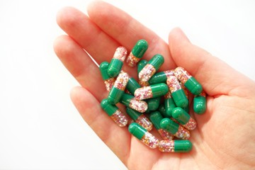 Multi-colored medical capsules, medicine closeup in hand on a white background. Cure Concept, healthcare, vitamins, medication. Top view with copy space for text.
