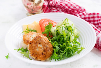 Ketogenic lunch. Chicken burger with tomato, cucumber, cheese and arugula salad without bun. Chicken patties. Healthy food. Keto/paleo diet.