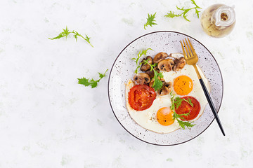 Ketogenic food. Fried egg, mushrooms and sliced tomatoes. Keto, paleo breakfast. Top view, overhead, copy space