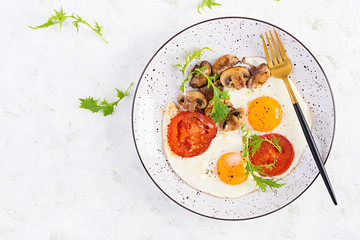 Ketogenic food. Fried egg, mushrooms and sliced tomatoes. Keto, paleo breakfast. Top view, overhead, copy space