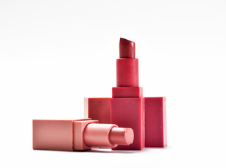 Used lipstick pink and nude on a white background.