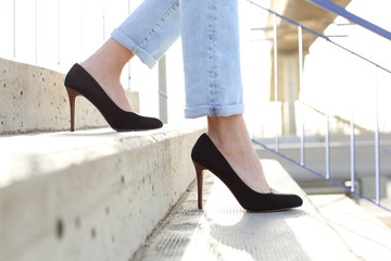 Profile of woman legs wearing high heels walking down stairs