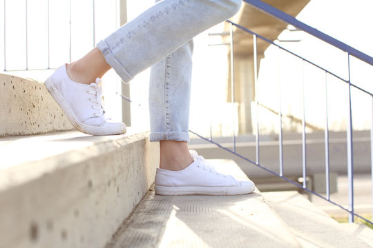 Profile Of Woman Legs Wearing Sneakers Walking Down Stairs