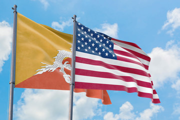United States and Bhutan flags waving in the wind against white cloudy blue sky together. Diplomacy concept, international relations.