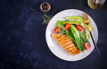 Chicken grilled fillet with salad fresh tomatoes and avocado. Healthy food, ketogenic diet, diet lunch concept. Keto/Paleo diet menu. Top view, flat lay