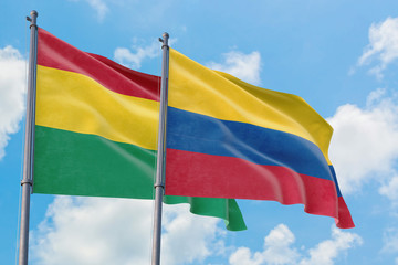 Colombia and Bolivia flags waving in the wind against white cloudy blue sky together. Diplomacy concept, international relations.