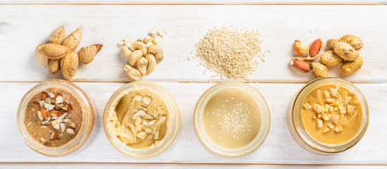 Fototapeta na wymiar Selection of nut butters - peanut, cashew, almond and sesame seeds, copy space